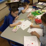 Kindergarten students working on writing in their classroom.