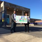 Principal Jenkins and a member of the Friend of Adaire Program pose with plans for the new school yard.