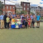 Students, Friends of Adaire Members and others pose with a Thank You Sign in the new school yard.