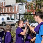 Adaire Playworks Junior Coach giving a high-five to a Playworks leader.